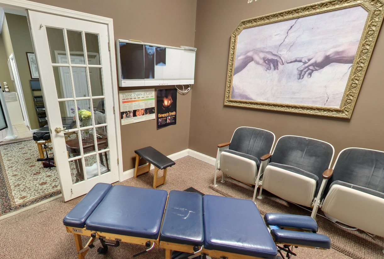 Treatment room with adjustment table and patient seating at our Lansing chiropractic office